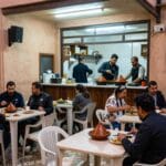 Cucina Marocchina: Piatti Tipici e Tradizioni da Provare 2026 6 Un piccolo ristorante locale a Marrakech con clienti marocchini che mangiano tajine a tavoli semplici