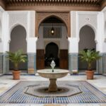 Cortile interno di un riad tradizionale a Fes con fontana centrale e architettura moresca